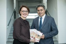 Das Bild zeigt Staatsministerin Widmann-Mauz und Professor Kizilhan bei der Übergabe des neuen Ratgebers Gewaltschutz in Deutschland.